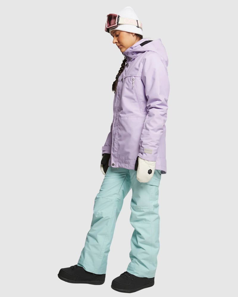 ROJO Adventure Awaits Pant in light blue, side view of women's insulated snow pants with a purple jacket.